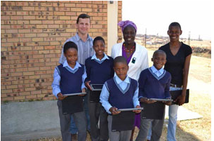 Mpumalanga iSchool coordinator Gerhard Oosthuizen, Vukuzenzele Combined School principal TE Mudau and National Rural Youth Services Corps participant Samukelisiwe Khumalo, with some the Grade 6 learners who are being taught with the help of iPads.