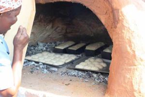 Lindiwe Nkosi checks bread and scones in the clay oven.