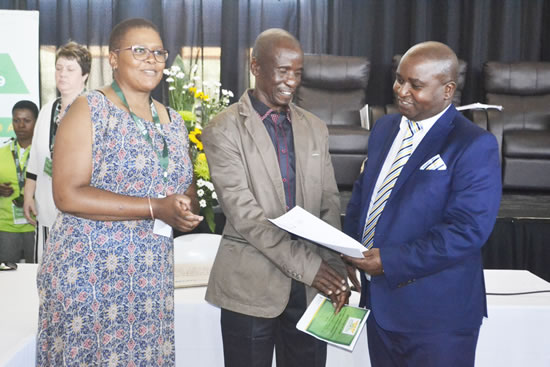 Rural Development and Land Reform Deputy Minister Mcebisi Skwatsha and CLCC Ntloko–Gobodo hand over a cheque to a family representative during a ceremony 