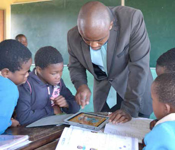 Mathematics teacher Lungisa Khanyile shows his learners how to use an iPad.