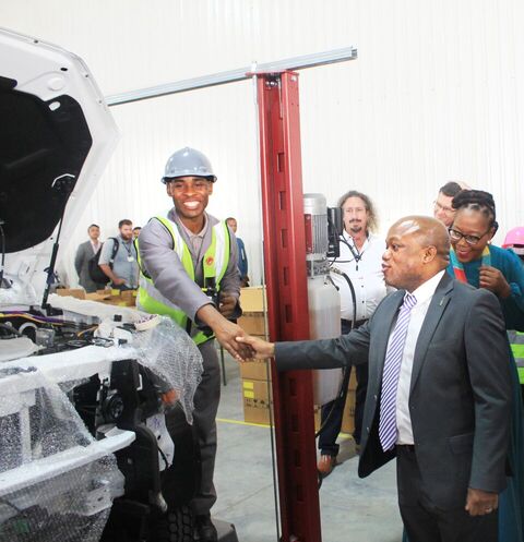 Sithembiso Mthembu employed at Mahindra Assembling Plant in Durban greeting the MEC for Economic Development, Tourism and Environmental Affairs Sihle Zikalala during the launch.