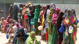 Somalians waiting in line for food aid .