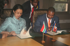 Minister of Agriculture, Forestry and Fisheries Tina Joemat-Petterson, left, and Swaziland's Minister of Tourism and Environmental Affairs, Macford Sibandze, signing in Pretoria.