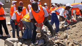 Volunteers from the National Youth Development Agency remove rubble from a building site hit by the Duduza tornado