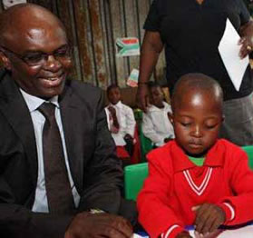 Finance MEC Mandla Nkomfe helps Grade 1 learners at Sihluziwe Primary School in Bronkhorstspruit get up to speed with their work on the first day of school. 