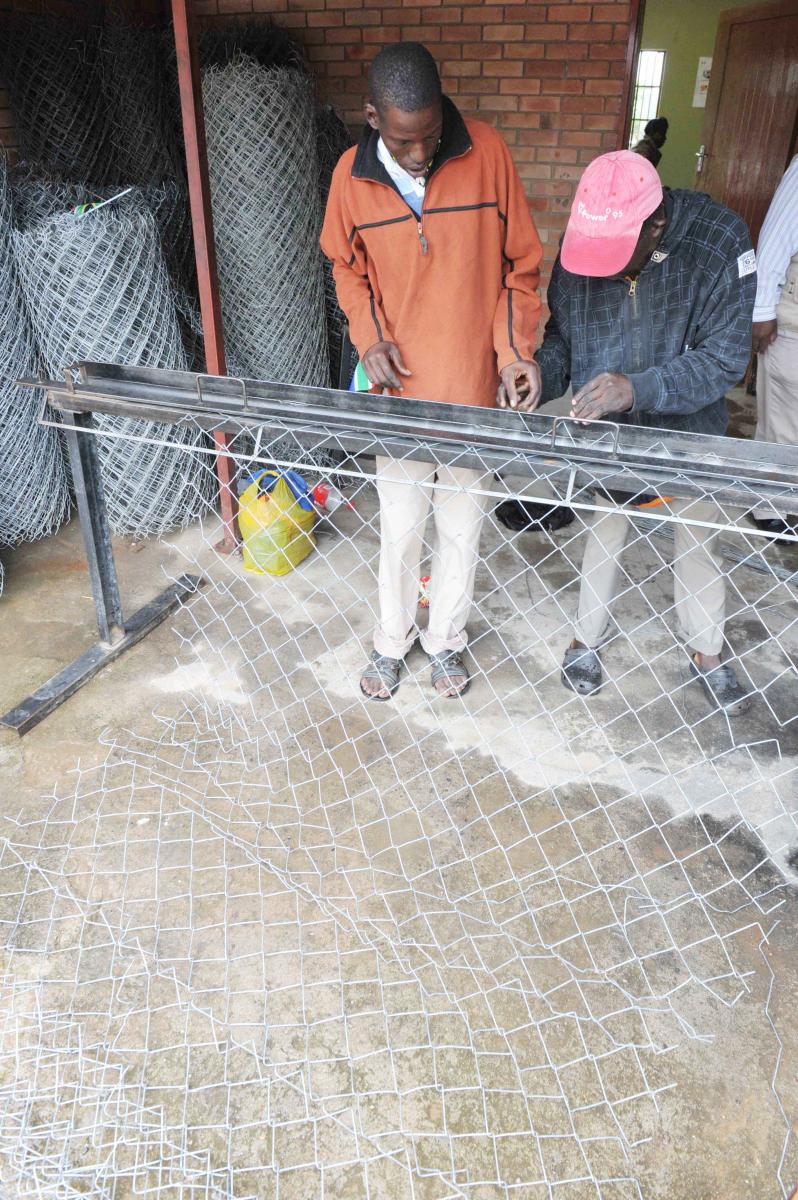 Workers at a steel small business putting finishing touches to one of their products