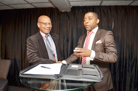 Vodacom Business chief officer Vuyani Jarana signs a partnership agreement with Vuyisile Ntlabati, the president of the Eastern Cape Chamber of Business. (Photo: Vodacom)