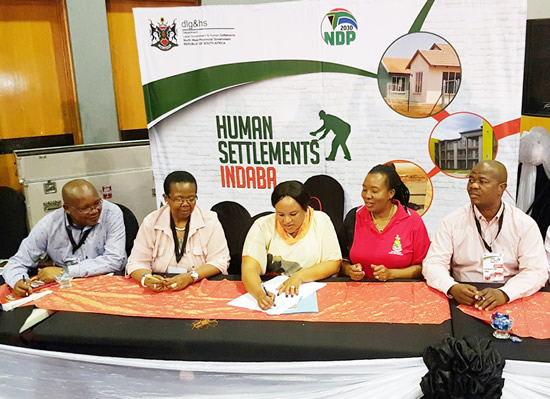 MEC Fenny Gaolaolwe signing a pledge at the recent Human Settlements Indaba in Rustenburg.