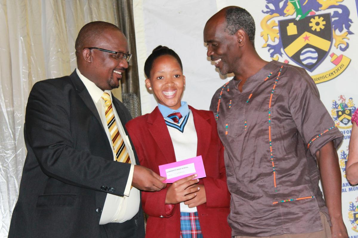 Rand West City Local Municipality mayor Mzikayifane Khumalo (left) handling over a bursary to a deserving learner.