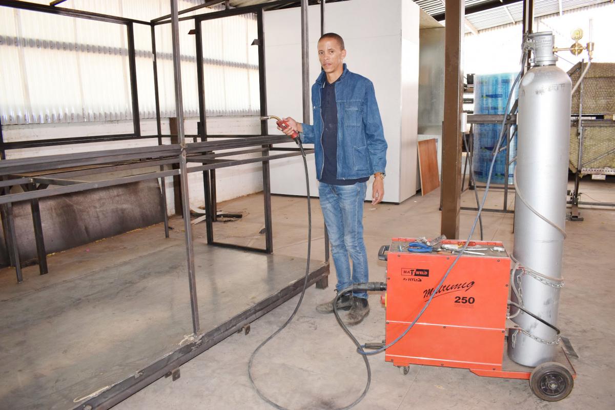 Itumeleng Leepile standing by one of his mobile kitchens.