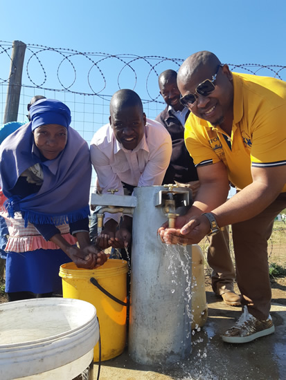 Nongoma resident Annie Myeni, Councillor Sthembiso Gumbi and Mhlathuze Water Interim CEO Mthokozisi Duze open a communal tap as part of a water infrastructural project.