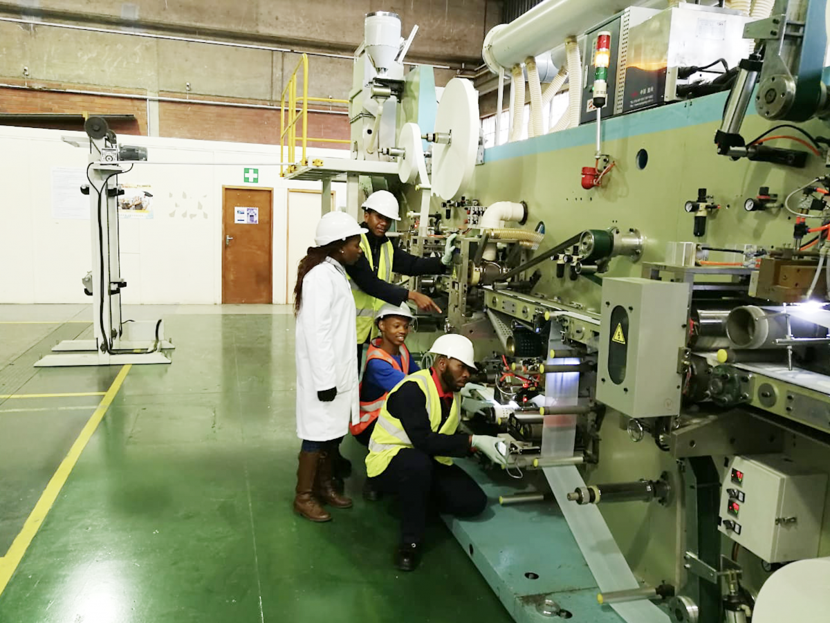 Technicians working on the machine that produces sanitary towels at Coastal College Skills Training Centre.