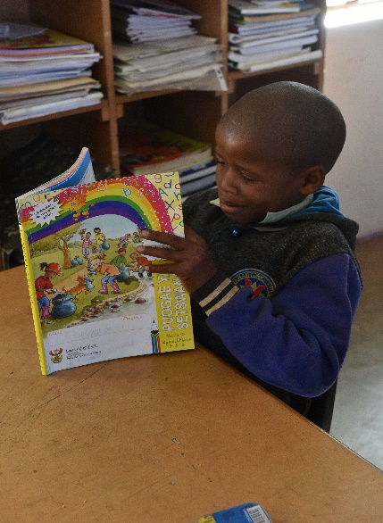 Loynatso Moluabi enjoying his reader thanks to the Department of Education’s Early Grade Reading Study (EGRS).