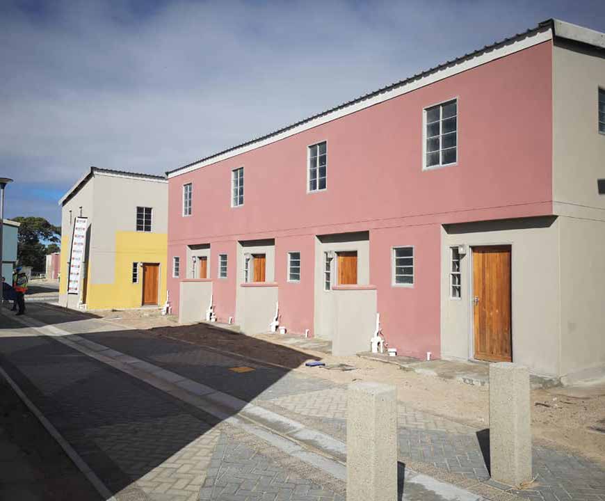 Elizabeth September stands outside of her new home donated by the Western Cape Human Settlements department.