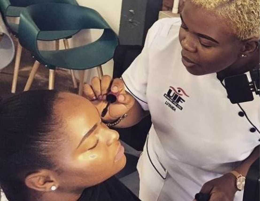 Labour Activations Programme (LAP) beneficiary Luyanda Luthuli applying makeup on one of her clients.