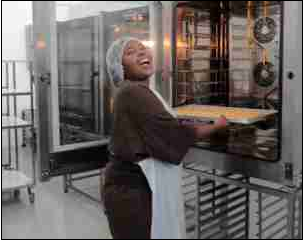 Noluvuyo Nekemfu bakes a batch of cookies at Khayelitsha Cookies, where she is employed. The business started with just two women and an oven and now employs 50.